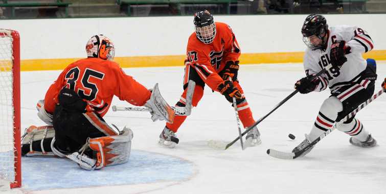Eden Prairie's John Sullivan, right, tried to control a bouncing puck as Grand Rapids defenseman Curtis Simonson (17) provides support for Thunderhawks goaltender Hunter Shepard. Photo by Loren Nelson