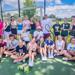 Roosevelt graduate Greg Wicklund poses with boys and girls tennis players at Lake Hiawatha during Teddy Tennis Camp