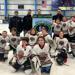 Members of Jr. Bears Squirt A team with coaches holding up championship banner