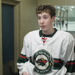 Minnesota Special Hockey player Brad Hutter standing in the hallway beside the hockey rink giving an interview