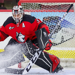 Northeastern goalie Gwyneth Philips, in the team's red and black jersey, looks to make a save in the crease. 