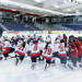 Liberty University players kneel in prayer on the ice. 