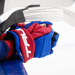 A closeup shot of a pair of blue and red TRUE gloves hang on the bench.