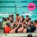 Image of Minneapolis Roosevelt TMT Swimmers huddled up with arms in center at the start of a meet