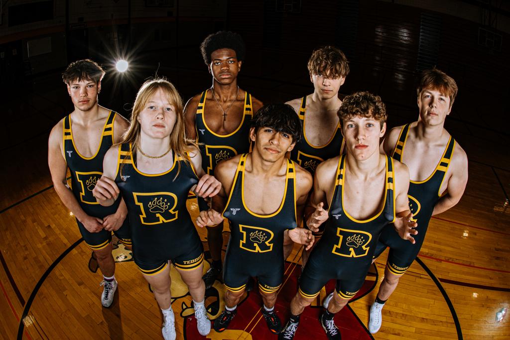 Image of the Minneapolis Roosevelt High School Teddy wrestlers pose in a red colored wrestling room on Teddy Wrestling Media Day