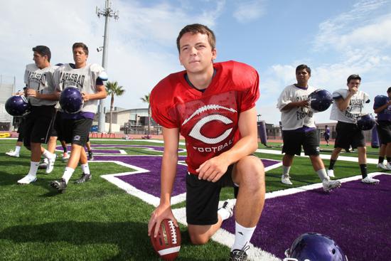 soccer player gives a boot on gridiron