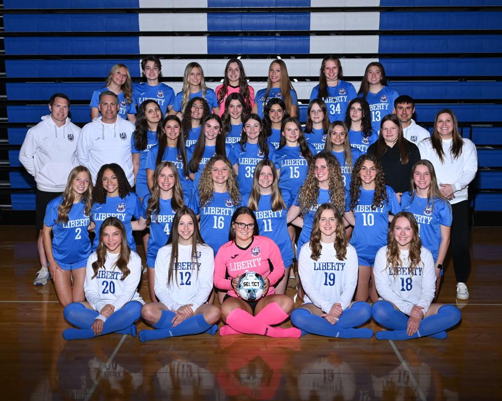 Women posing in front of a camera in a team photo