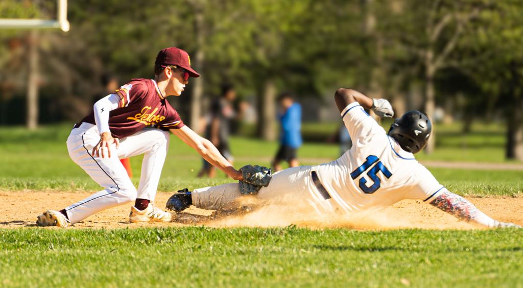 Image of the Minneapolis Roosevelt High School Teddy Baseball Second Baseman applying a tag on his opponent as he attempts to steal 2nd base